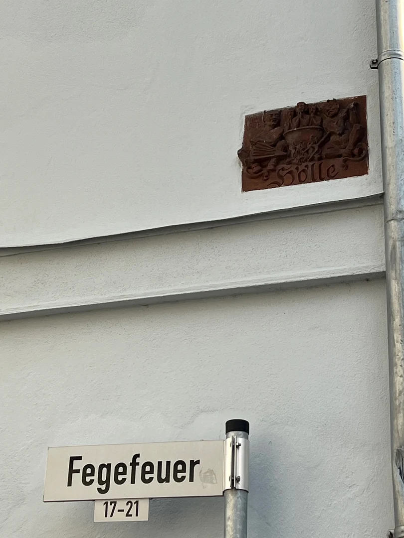 Eine Wissenschaftlerin und ein Wissenschaftler arbeiten hinter einer Glasfassade und mischen Chemikalien mit Großgeräten.